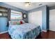 Blue bedroom with hardwood floors, a ceiling fan, closet with white doors and a large window at 1108 16Th Nw Ave, Clearwater, FL 33756
