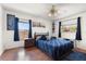 Cozy bedroom with hardwood floors, natural light, ceiling fan, and comfortable bed with a bedside table at 1108 16Th Nw Ave, Clearwater, FL 33756