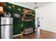 An indoor bar on a green wall next to the refrigerator features decorative items and a cozy ambiance at 1108 16Th Nw Ave, Clearwater, FL 33756