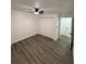 This bedroom features a ceiling fan, closet, fresh paint, and wood-look floors at 112 N Betty Ln, Clearwater, FL 33755