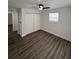 Bright bedroom with sleek floors, a ceiling fan, and a spacious closet, offering practical and comfortable living at 112 N Betty Ln, Clearwater, FL 33755