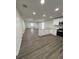 An open floor plan features a modern kitchen with white cabinets and stainless steel appliances at 112 N Betty Ln, Clearwater, FL 33755