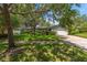 Charming single-story home with lush green lawn and mature trees offering shade at 1340 Whispering Pines Dr, Clearwater, FL 33764