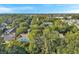 Aerial view of townhouses surrounded by trees in a neighborhood, with blue skies above at 13777 Forest Lake Dr, Largo, FL 33771