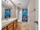 Full bathroom showcasing cultured marble countertop, travertine tile, and tub/shower combo with blue rose curtain at 13777 Forest Lake Dr, Largo, FL 33771
