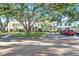 A row of townhouses featuring a shared parking lot with a red car, and manicured landscaping at 13777 Forest Lake Dr, Largo, FL 33771
