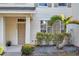 Townhouse exterior featuring a palm tree, well-maintained facade and manicured bushes at 13777 Forest Lake Dr, Largo, FL 33771