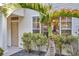 Home exterior featuring tropical landscaping, front door, and well-maintained facade at 13777 Forest Lake Dr, Largo, FL 33771