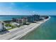 Stunning aerial view of beachfront condominiums, pristine sands, and crystal-clear waters at 1480 Gulf Blvd # 103, Clearwater Beach, FL 33767