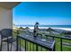 Relaxing balcony with table and chairs overlooking a pristine beach and turquoise water at 1480 Gulf Blvd # 103, Clearwater Beach, FL 33767