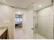 Modern bathroom features a glass shower and tile flooring, adjacent to the main bedroom at 1480 Gulf Blvd # 103, Clearwater Beach, FL 33767
