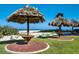 Enjoy beachfront bliss with these charming tiki umbrellas on lush green grass, ideal for relaxation by the ocean at 1480 Gulf Blvd # 103, Clearwater Beach, FL 33767