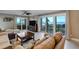Cozy living room featuring tile flooring, a ceiling fan, and sliding glass doors with beach views at 1480 Gulf Blvd # 103, Clearwater Beach, FL 33767