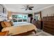 Spacious main bedroom with balcony access, a ceiling fan, and classic wooden furniture at 1480 Gulf Blvd # 103, Clearwater Beach, FL 33767