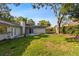Spacious backyard featuring lush green grass and mature trees, perfect for outdoor activities at 15118 Brushwood Dr, Tampa, FL 33624