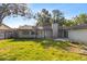 Backyard showcasing a lush lawn, patio area, and mature trees, ideal for outdoor activities and relaxation at 15118 Brushwood Dr, Tampa, FL 33624