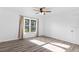 An empty bedroom boasts wood-look floors, bright window, ceiling fan, and neutral walls for versatile decor at 15118 Brushwood Dr, Tampa, FL 33624