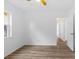 Spacious bedroom with wood-look flooring, a ceiling fan, and door leading to the hallway at 15118 Brushwood Dr, Tampa, FL 33624
