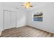 Well-lit bedroom with wood-look flooring, a ceiling fan, and a double door closet at 15118 Brushwood Dr, Tampa, FL 33624