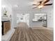 Bright living room featuring a brick fireplace, wood floors, and an open layout with easy access to kitchen at 15118 Brushwood Dr, Tampa, FL 33624