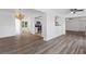Open-concept room featuring wood floors, white walls, and seamless connection to the kitchen and dining area at 15118 Brushwood Dr, Tampa, FL 33624