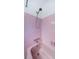 Bathroom featuring a pink tiled wall, bathtub with a shower head, and faucet at 1524 Lemon St, Clearwater, FL 33756