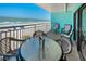 Balcony overlooking the ocean with seating for four and an ice bucket with champagne at 19440 Gulf Blvd # 306, Indian Shores, FL 33785