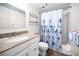 Bathroom with granite vanity top and shower with floral shower curtain at 19440 Gulf Blvd # 306, Indian Shores, FL 33785