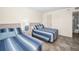 Bedroom featuring two beds with blue-and-white striped bedding, and nightstand with accent lamp at 19440 Gulf Blvd # 306, Indian Shores, FL 33785