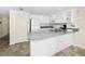 Bright kitchen featuring white cabinets, modern appliances, and granite countertops for a clean and functional space at 19440 Gulf Blvd # 306, Indian Shores, FL 33785