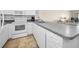Well-lit kitchen featuring white cabinets, granite countertops and stainless steel sink at 19440 Gulf Blvd # 306, Indian Shores, FL 33785