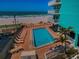 Aerial view of community pool, ocean and tanning deck with multiple chairs at 19440 Gulf Blvd # 306, Indian Shores, FL 33785