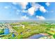 Breathtaking aerial view of a community surrounded by lush greenery, serene lakes and waterways under a bright, sunny sky at 2250 Mountain Ash Way, New Port Richey, FL 34655