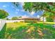 The backyard features a manicured lawn, putting green, and screened-in pool at 2250 Mountain Ash Way, New Port Richey, FL 34655