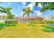 Beautiful screened-in pool area framed by lush landscaping and mature palm trees, ideal for relaxation and privacy at 2250 Mountain Ash Way, New Port Richey, FL 34655