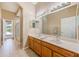 Bright bathroom featuring a double vanity, large mirror, and tiled flooring at 2250 Mountain Ash Way, New Port Richey, FL 34655