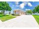 Beautiful home with a three-car garage, manicured lawn, and lush landscaping, offering a welcoming curb appeal at 2250 Mountain Ash Way, New Port Richey, FL 34655