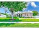 Charming home featuring lush landscaping, a well-manicured lawn, and mature shade trees at 2250 Mountain Ash Way, New Port Richey, FL 34655