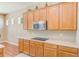 Functional kitchen featuring a microwave, cooktop, and plenty of storage at 2250 Mountain Ash Way, New Port Richey, FL 34655