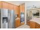 Well-lit kitchen with stainless steel refrigerator and built-in oven at 2250 Mountain Ash Way, New Port Richey, FL 34655