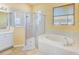 Bright bathroom features a shower and separate soaking tub with tile surround at 2250 Mountain Ash Way, New Port Richey, FL 34655