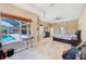 Spacious main bedroom with a pool view, ceiling fan and travertine floors at 2250 Mountain Ash Way, New Port Richey, FL 34655