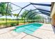 An enclosed pool and spa area is set in a private backyard with green space at 2250 Mountain Ash Way, New Port Richey, FL 34655