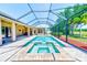 A screened in pool and spa with brick paver decking offers an outdoor entertainment area at 2250 Mountain Ash Way, New Port Richey, FL 34655
