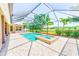 Screened-in pool with a hot tub, surrounded by well-maintained landscaping and brick pavers at 2250 Mountain Ash Way, New Port Richey, FL 34655