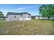 Lush backyard with a well-maintained lawn, mature tree, and a gray vinyl sided home at 262 S Port Royal Ln, Apollo Beach, FL 33572