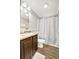 Bathroom features a single sink vanity with wood-look floors and shower with curtain at 262 S Port Royal Ln, Apollo Beach, FL 33572