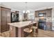 Kitchen with island and seating featuring wood cabinets, black appliances, and modern lighting fixtures at 262 S Port Royal Ln, Apollo Beach, FL 33572