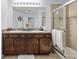 Bathroom featuring a double vanity, large mirror, and glass-enclosed shower at 27549 Stonecreek Way, Wesley Chapel, FL 33544