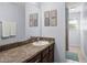 Bathroom showcasing a spacious vanity with sink, mirror, and tile flooring adjacent to shower at 27549 Stonecreek Way, Wesley Chapel, FL 33544